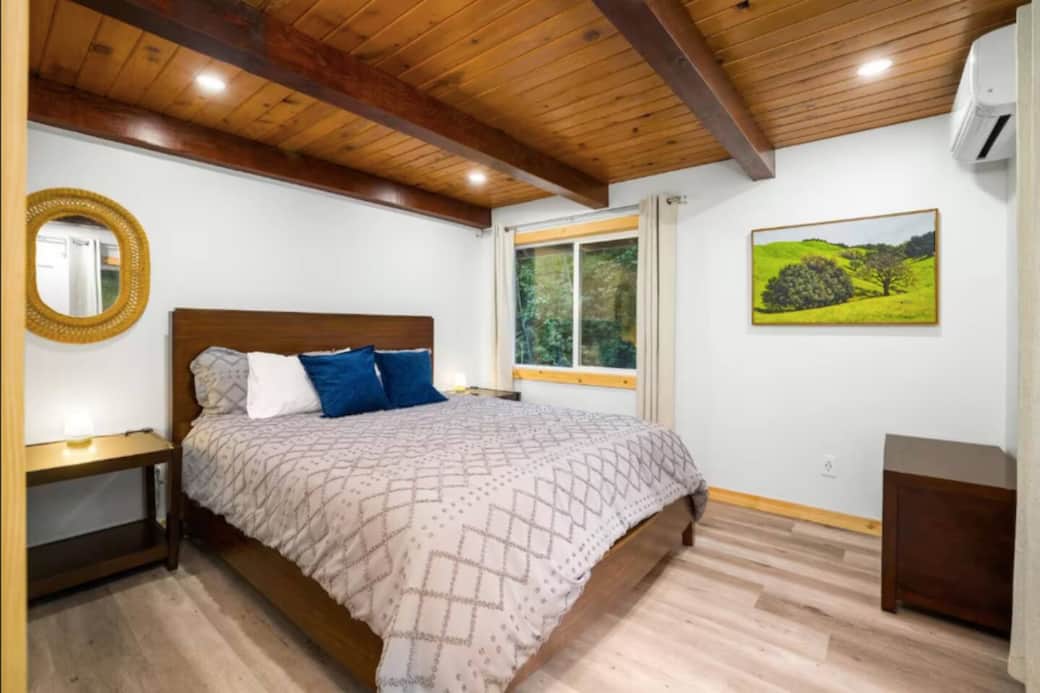 Comfortable bedroom with a queen bed, serene forest views, and individual heating/AC for your ideal sleep.