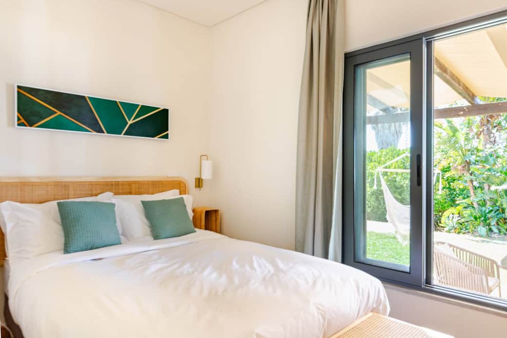 Second bedroom with comfy bedding & serene decor — designed for restful sleep & longer stays. Stays cool in the summer with ceiling fan and mosquito net. 