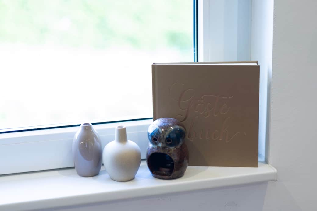 Detailkultur: Stilvolle Dekoration mit Vase, Kerze und Gästebuch unterstreicht die persönliche Note.