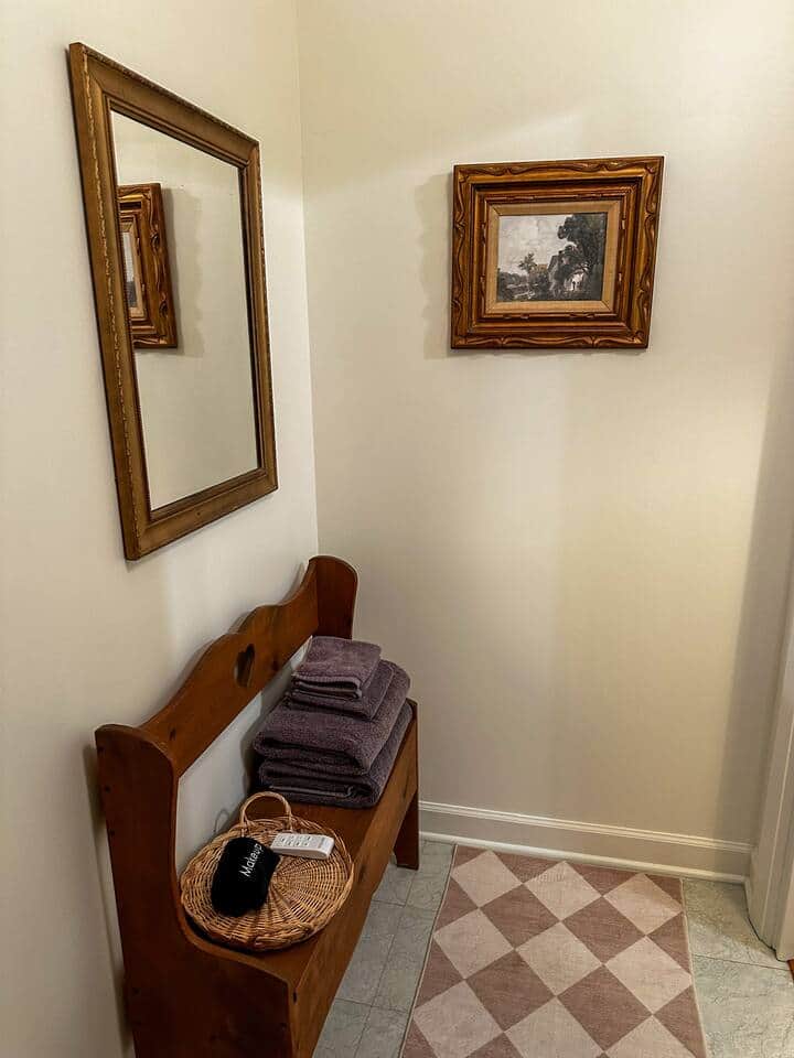This walk in closet is stocked with towels for each guest, including a towel for makeup removal. An extra blanket is located under the seat of this bench with another on top of the clothes hanging space.