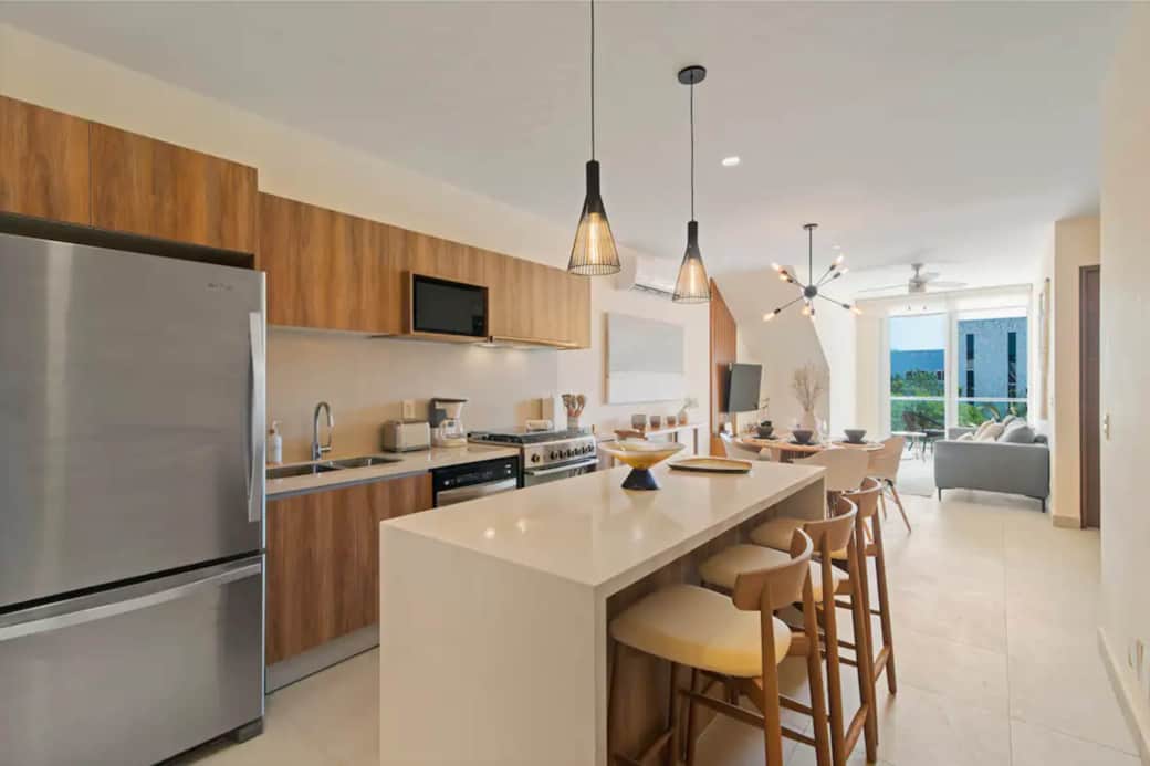 Seaside living: Penthouse with stocked kitchen, cozy living, elegant dining, private balcony.