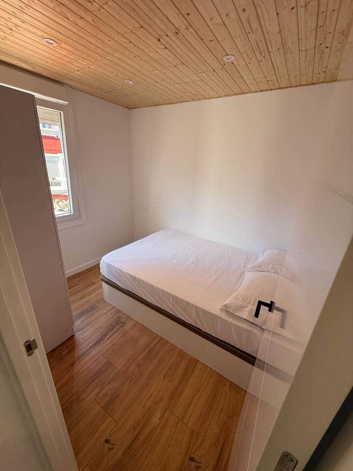 Dormitorio con cama doble y techo de madera