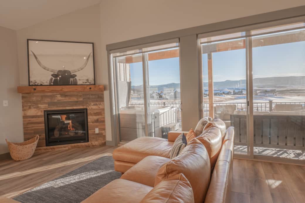 A bright, open living room with stunning views of the golf course and surrounding mountains.