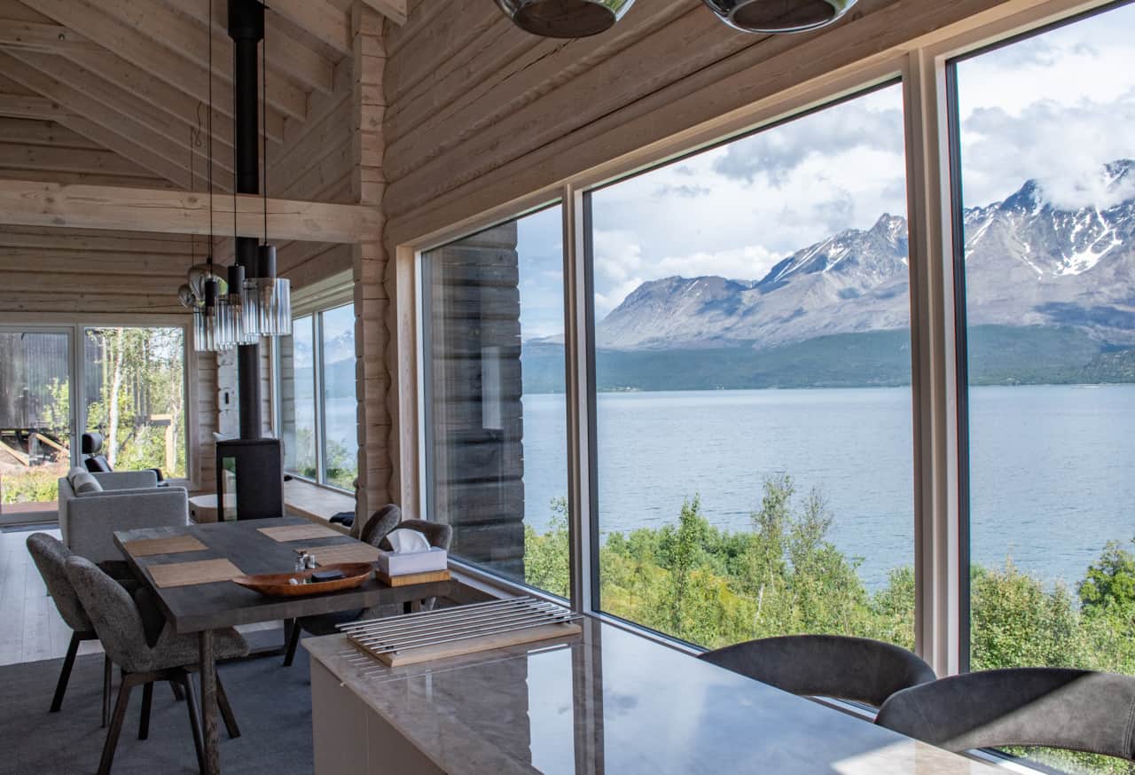 Pendant lights over the table, the fjord running the width of the room.