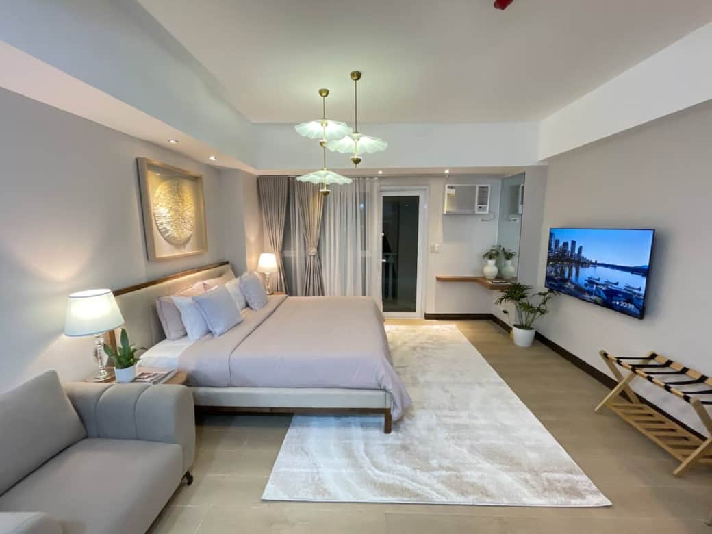 The studio unit is equipped with a king-size bed, cozy bedding, blackout curtains, and a 55-inch smart 4K TV.