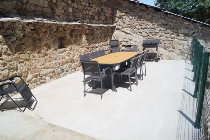 Terrasse avec barbecue au charbon et table de repas