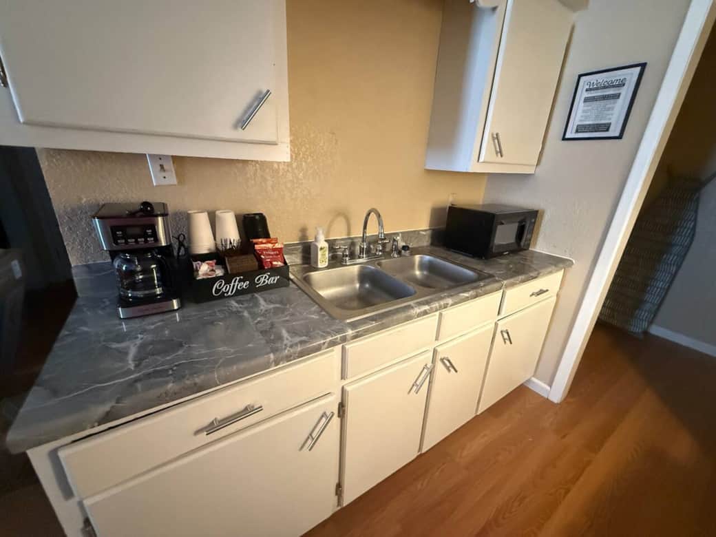 Full kitchen with stove, oven, refirigerator, microwave, coffee machine, coffee, sugar and cream. There’s also some to go coffee cups with it’s lids. 