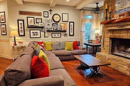 A cozy family room with a wood burning fireplace and loads of seating.