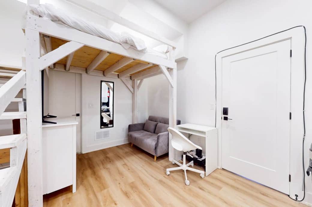 Living room with a platform bed above it