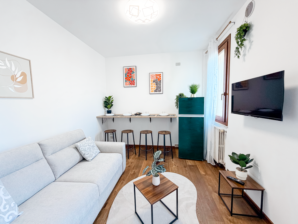 Helles Wohnzimmer mit Schlafsofa und Essbereich, perfekt für Aufenthalte am Gardasee.