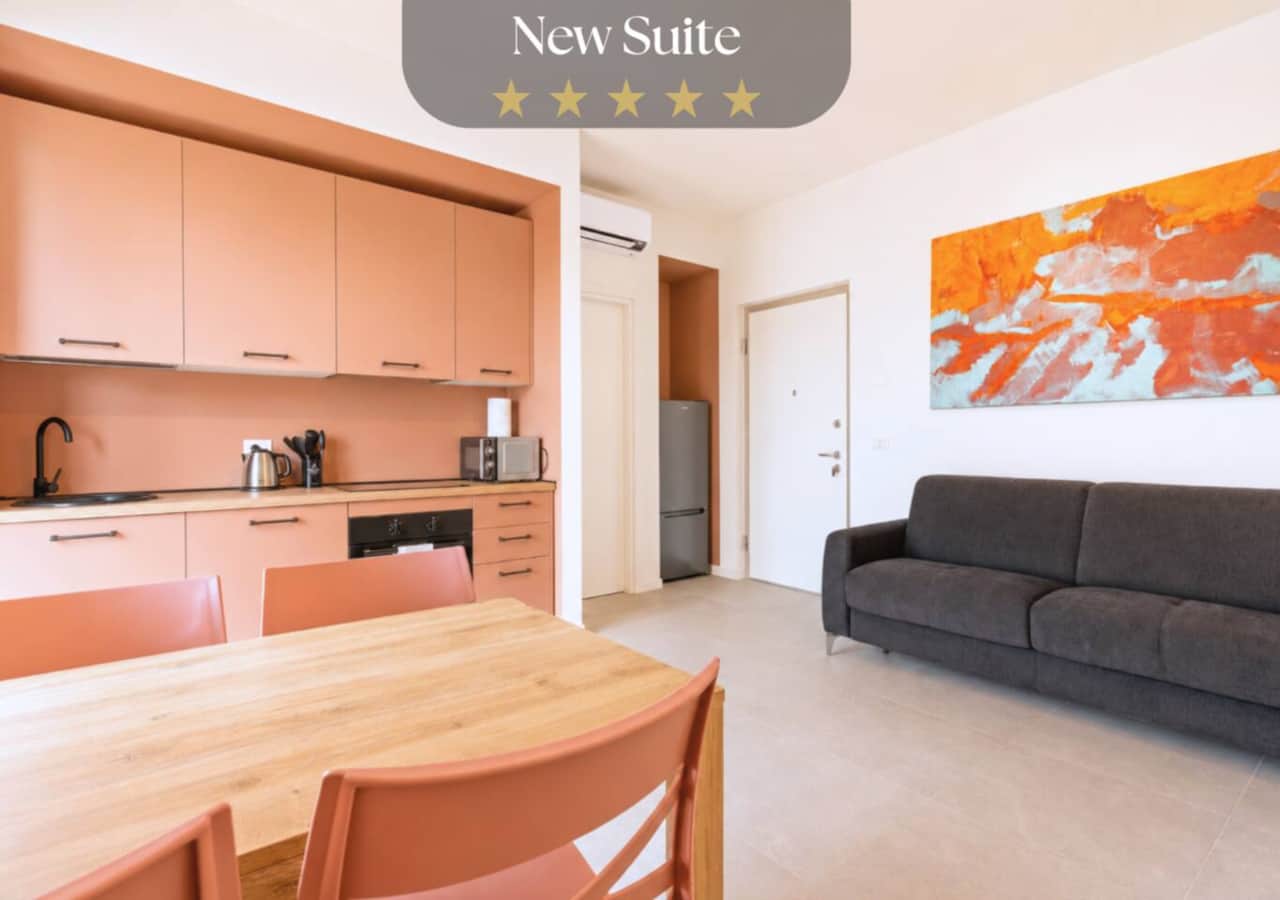 Soggiorno con divano letto, tv, tavolo da pranzo e cucina open space, con accesso al balcone e bella vista