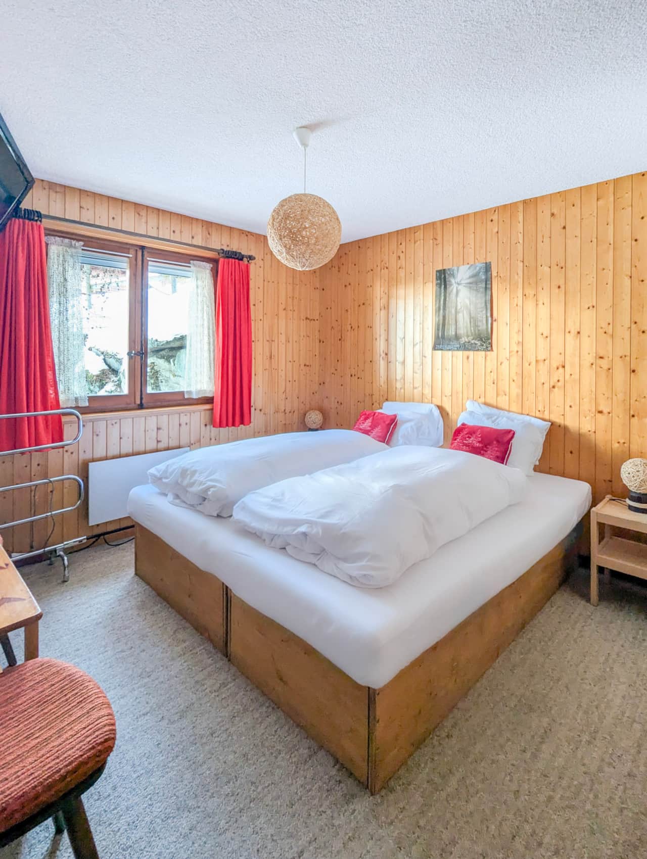 Zimmer 1 mit einem großen Doppelbett und einem Fernseher.
