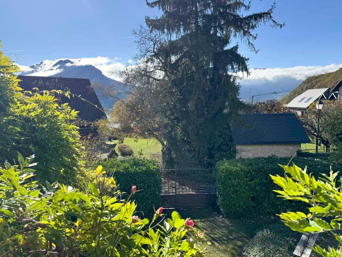 Côté lac : exposition Ouest depuis le salon avec vue sur le jardin, le Taillefer et le Roc de Chère