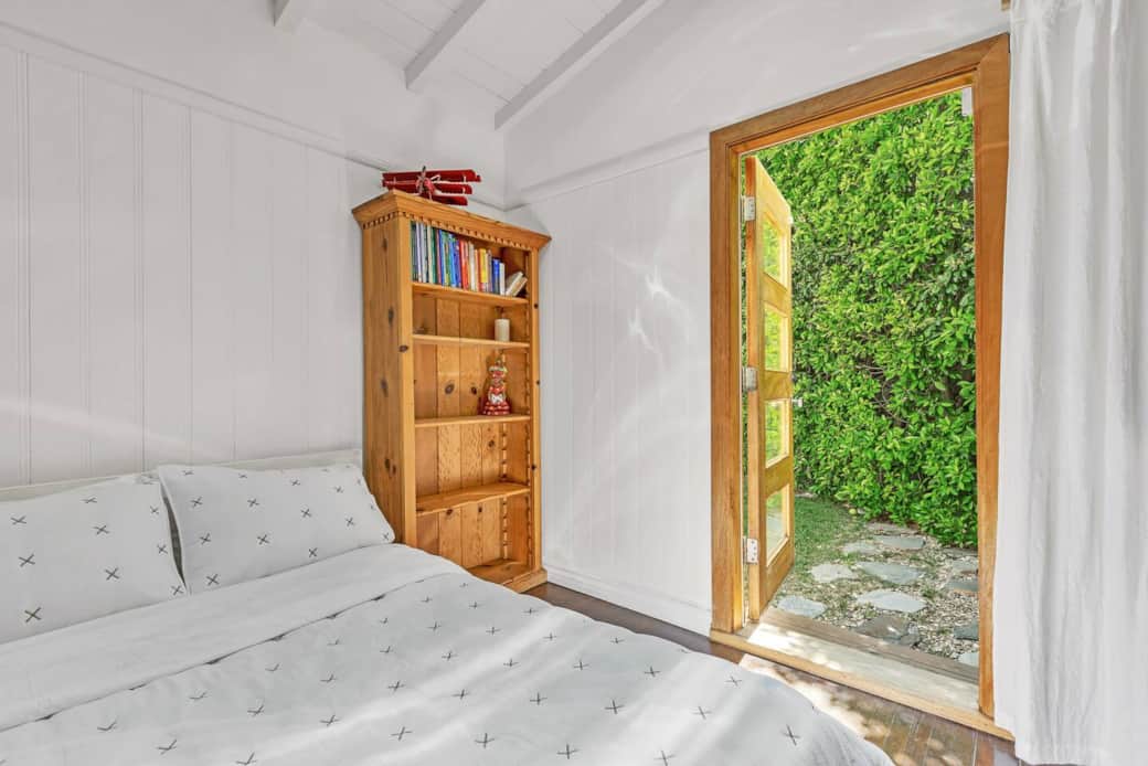 Offering a cozy Full-size bed, paired with a classic wooden bookshelf for a cozy stay.