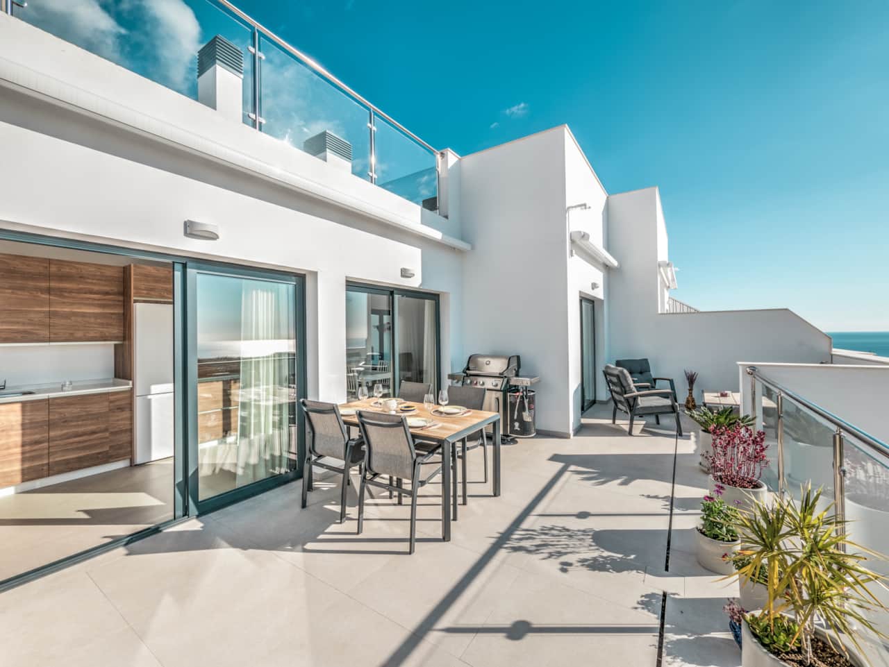 Su terraza privada con zona de comedor y salón.