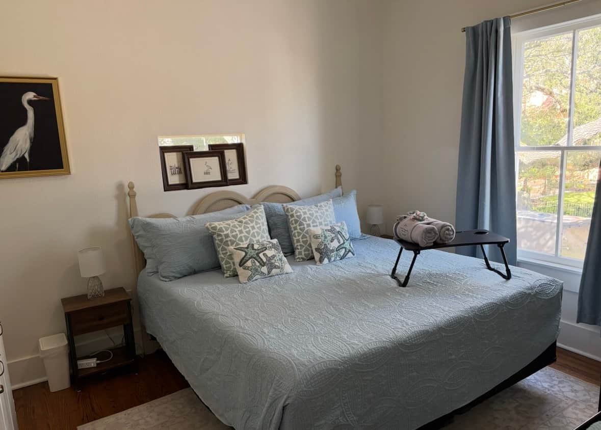 King bedroom at White Magnolia Galveston with coastal décor and TV