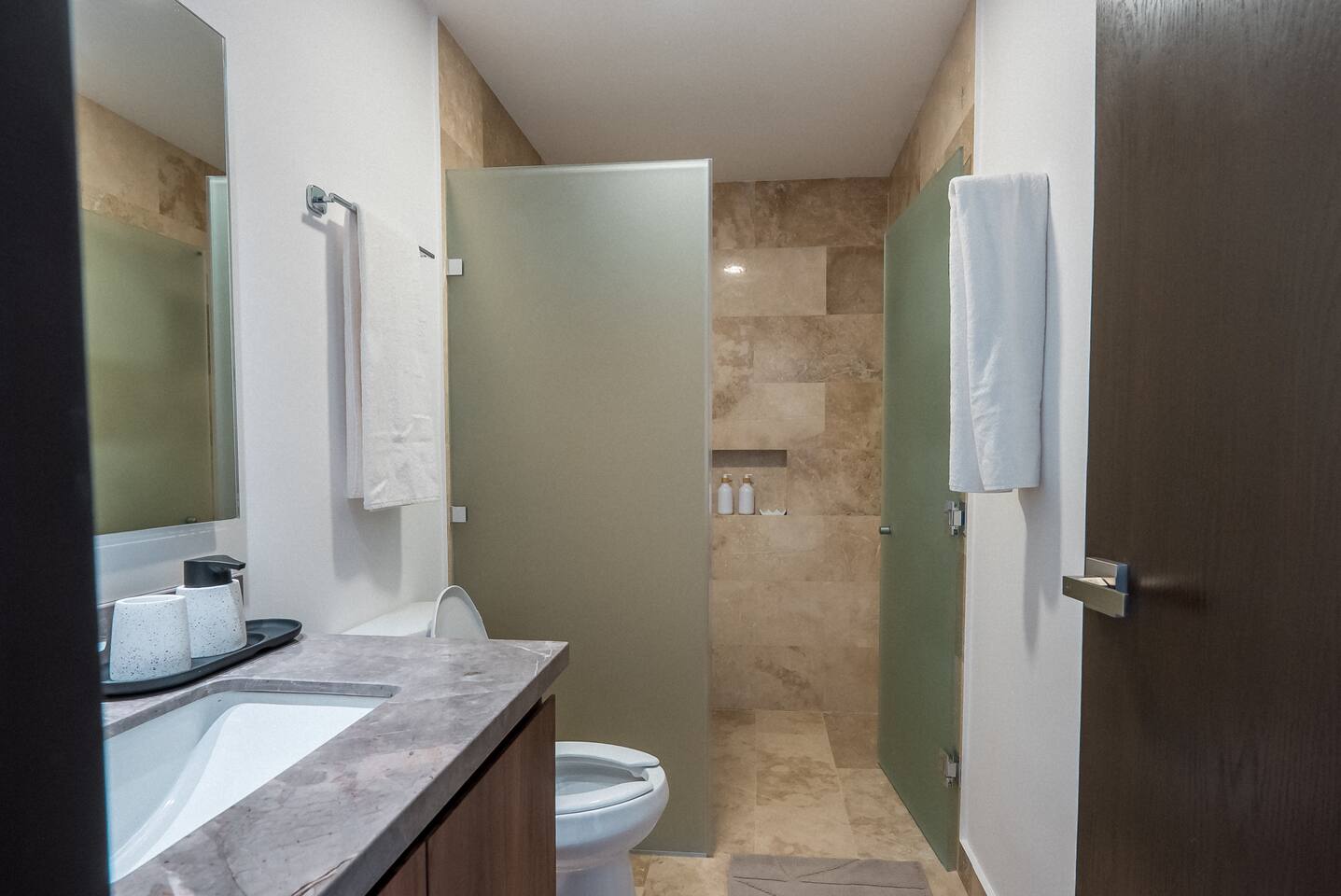 Refréscate en este moderno baño equipado con shampoo, acondicionador, jabón corporal, jabón de manos, papel higiénico, toallas de baño, toallas de mano y secadora de cabello para tu estancia.