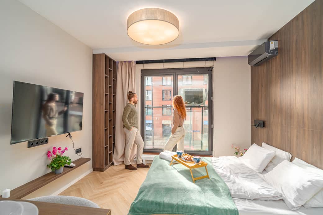 Jasna, funkcjonalna przestrzeń wypoczynkowa z dużym łóżkiem i panoramicznym oknem.