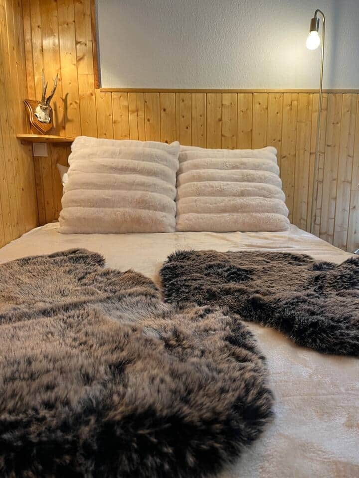 Le lit en 140x190 et ses plaids en fourrure toute douce 