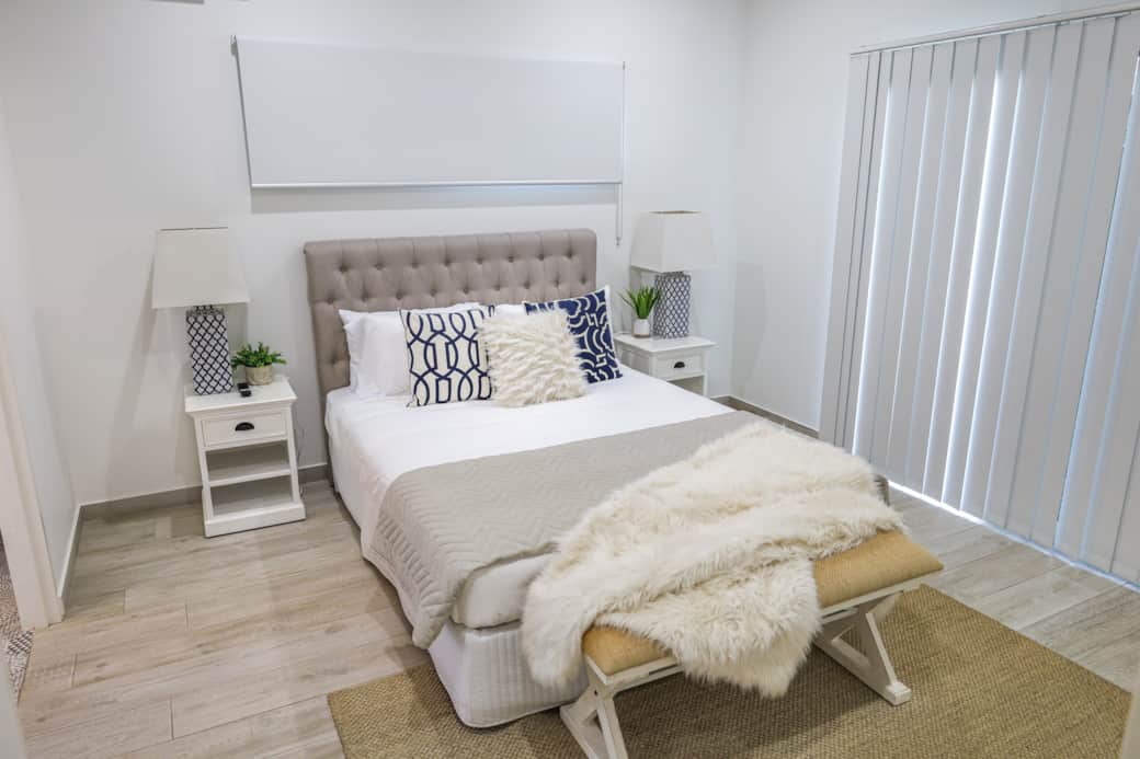 Bright and serene master bedroom with queen bed, garden views, soft light, and air-conditioning