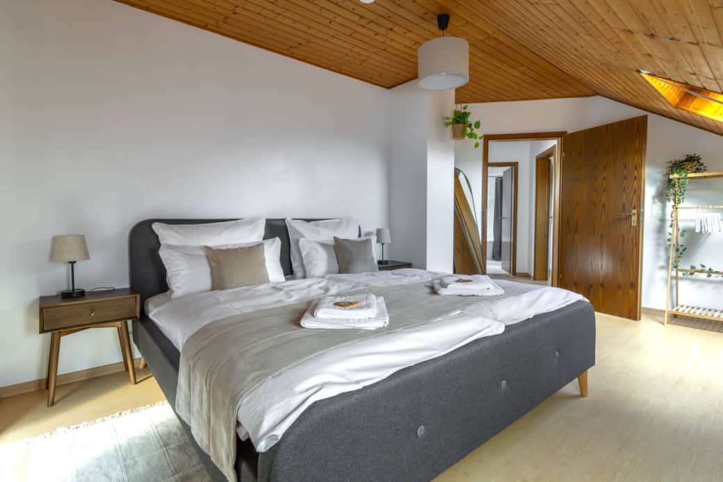 Schlafzimmer mit Doppelbett und angenehmer Raumhöhe