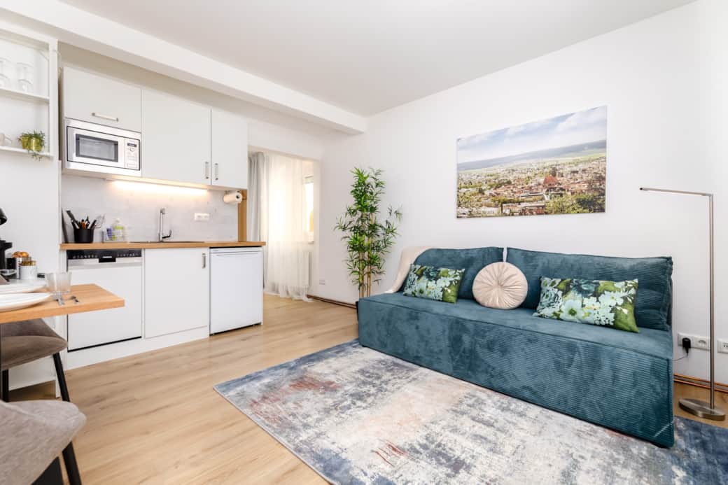 Blick ins Studio - mit kleiner Küche, (Ess-)Tisch und Couch