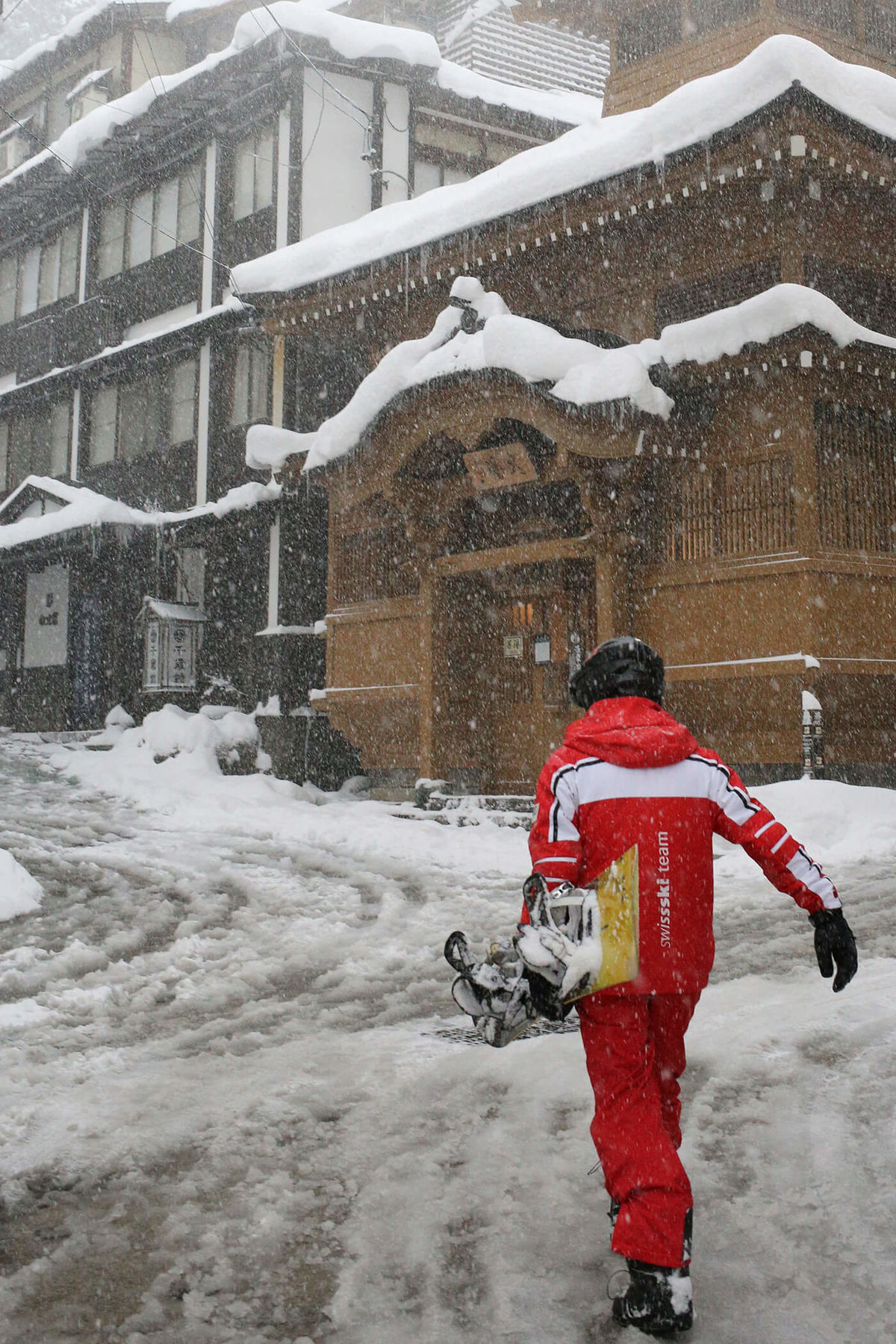 snowboarder walking to the Yu Road escalator Nozawa Onsen