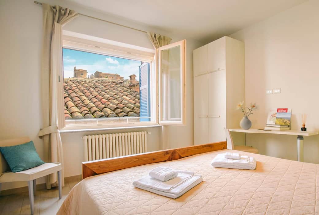 Elegante e silenziosa camera da letto, con ampia finestra con vista sul borgo di La Morra