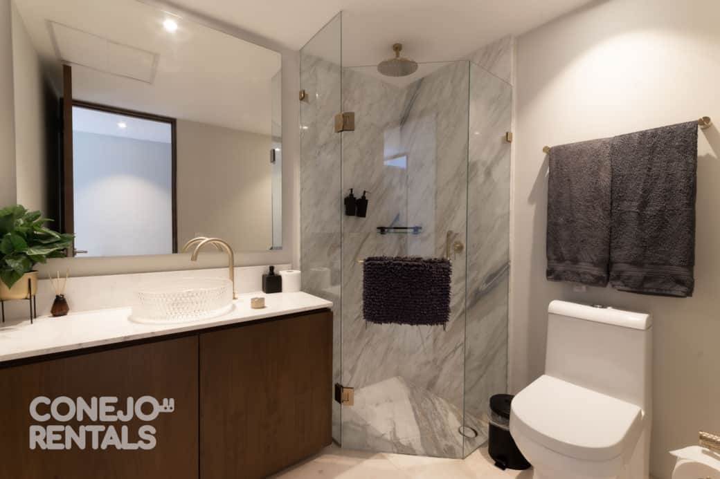 Baño moderno con mármol y luz natural diseño elegante en Bolongo Baño moderno con mármol y luz natural diseño elegante en Bolongo