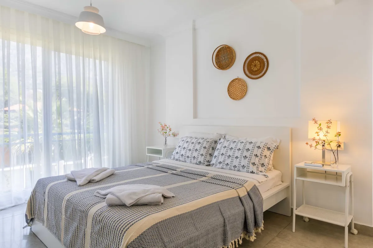 Bedroom with a double bed, bedside tables, and large windows with sheer curtains, Villa Nergis 2, Gocek.