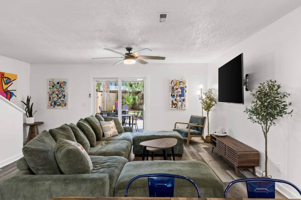 Gather on the oversized sectional for movies on the large smart TV or enjoy the provided board games. High-speed Wi-Fi, air conditioning, colorful midcentury-inspired art, and direct patio access make this a welcoming space between beach outings