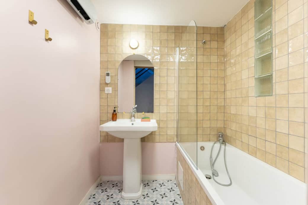 La salle de bain beige avec baignoire La salle de bain beige avec baignoire