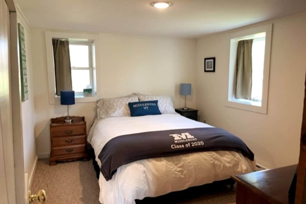Private bedroom with queen bed, night tables, large dresser with mirror, and en suite full bathroom
