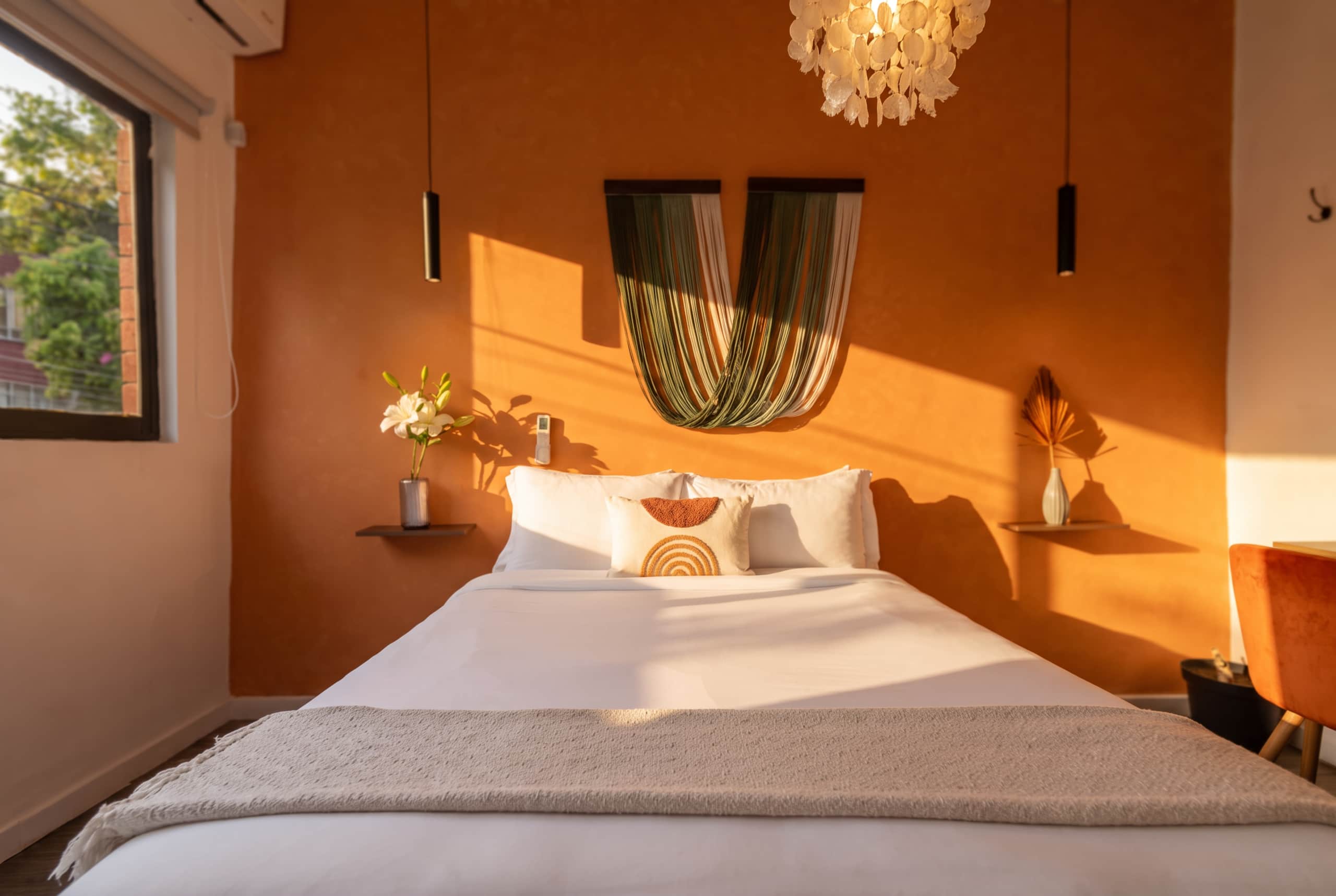 Terracotta bedroom with a woven headboard at Casa Atlixco