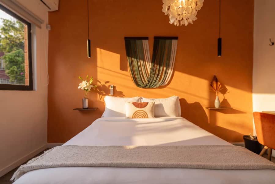 Terracotta bedroom with a woven headboard at Casa Atlixco