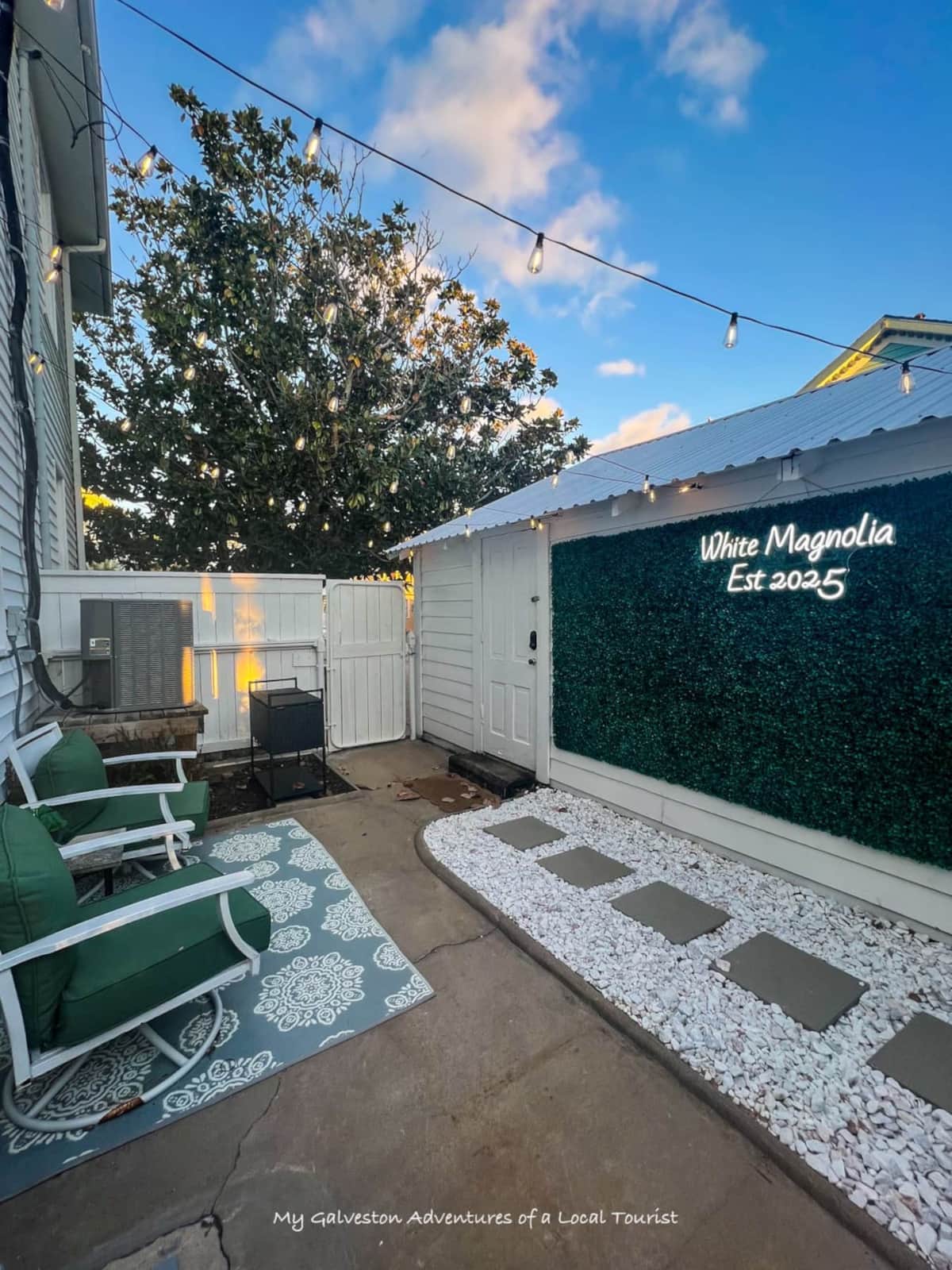 Private courtyard at White Magnolia Galveston with string lights and seating