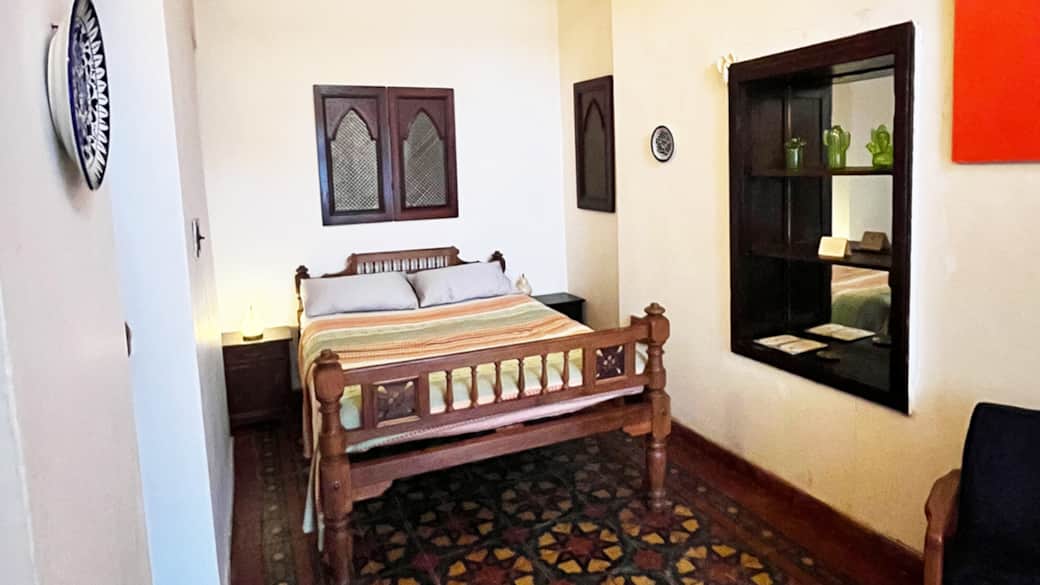 Art Deco echoes in restored rosewood furniture, set against vibrant Kashish tiles.