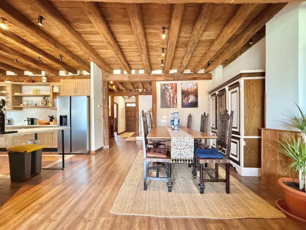 Comedor espacioso con gran mesa de madera, ideal para reunir a familias y grupos. Decoración rústica con toques modernos que invitan a compartir comidas y buenos momentos.