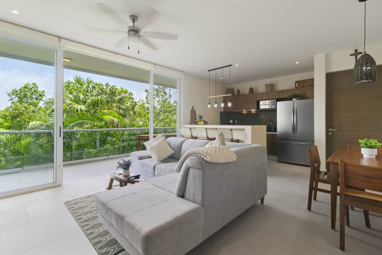 Relax in our cozy living room with patio access, jungle views, plush couch, and smart TV.