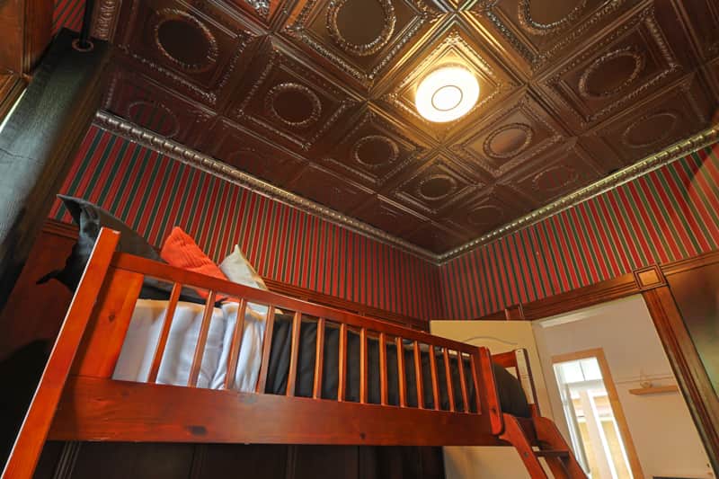 Deuxième chambre au style unique avec plafond ornemental et lit superposé double et simple.