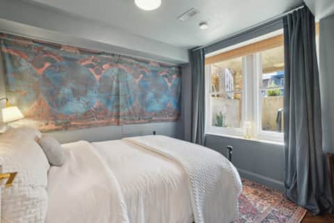 First queen bedroom with map mural and blackout curtains at Capitol Hill East House