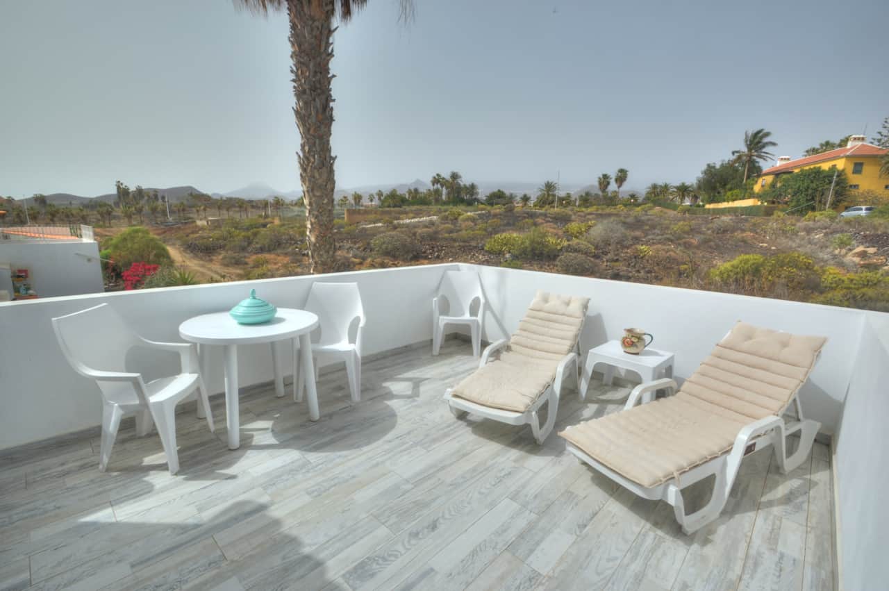 Uncovered terrace with sunbeds table and chairs