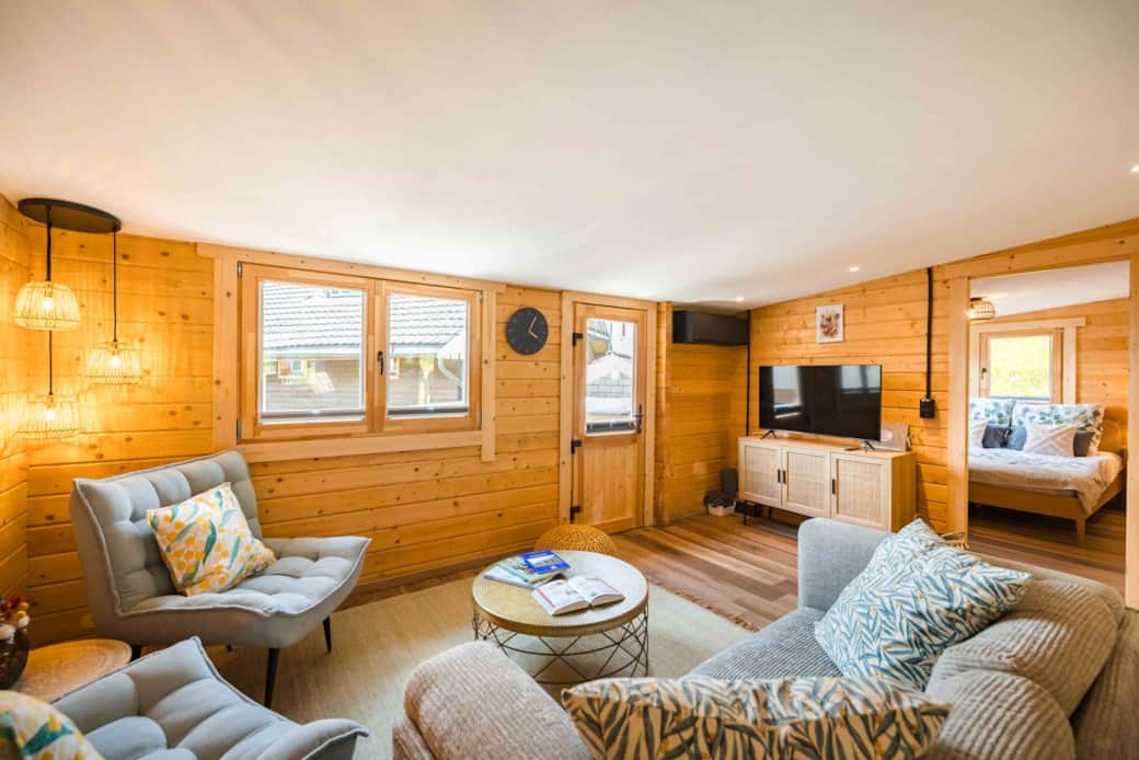 Bright living room with TV and bedroom access in Chalet Oz Swiss chalet Bright living room with TV and bedroom access in Chalet Oz Swiss chalet