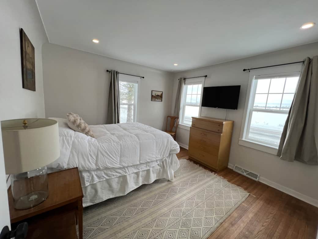 Main floor bedroom 1 with full bed, blackout and light filtering curtains and a 40" smart tv with disney+/hulu bundle