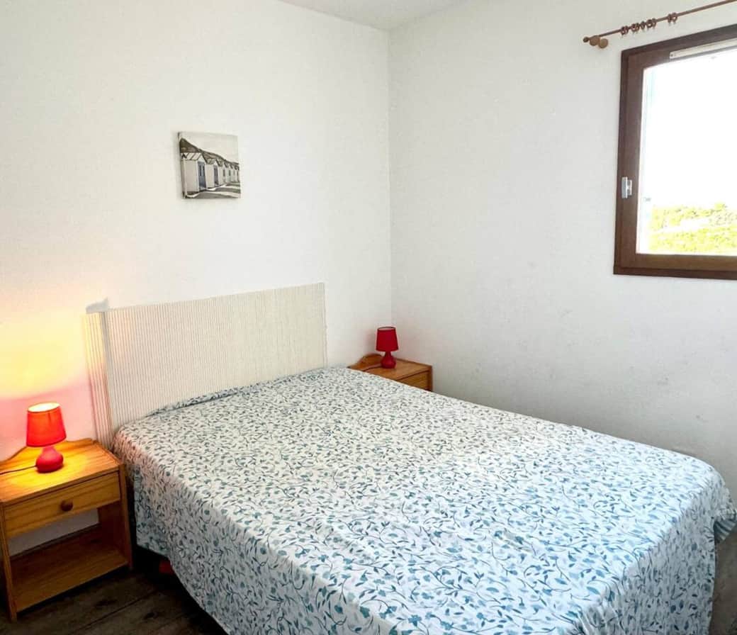 Chambre lumineuse avec lit double, décoration sobre et tables de chevet. Offrez-vous des nuits reposantes avant de rejoindre la plage et l’Allée des Pins à pied, ou de découvrir Collioure et profiter des feux d’artifice estivaux sur le port.