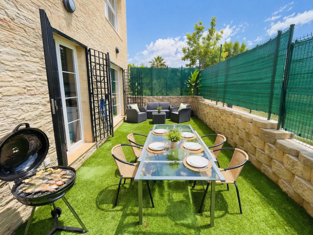 Patio soleado con parrilla y comedor Patio soleado con parrilla y comedor