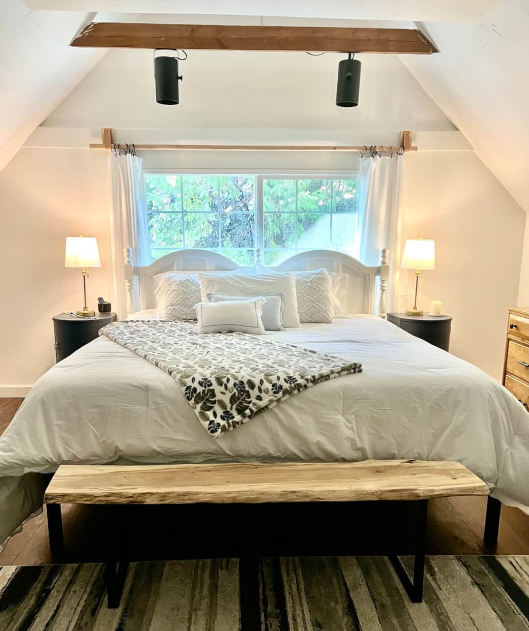 Spacious and serene. This master bedroom features a luxurious king-size bed, a handcrafted Myrtlewood bench, and treetop views that bring in the calming feel of nature.