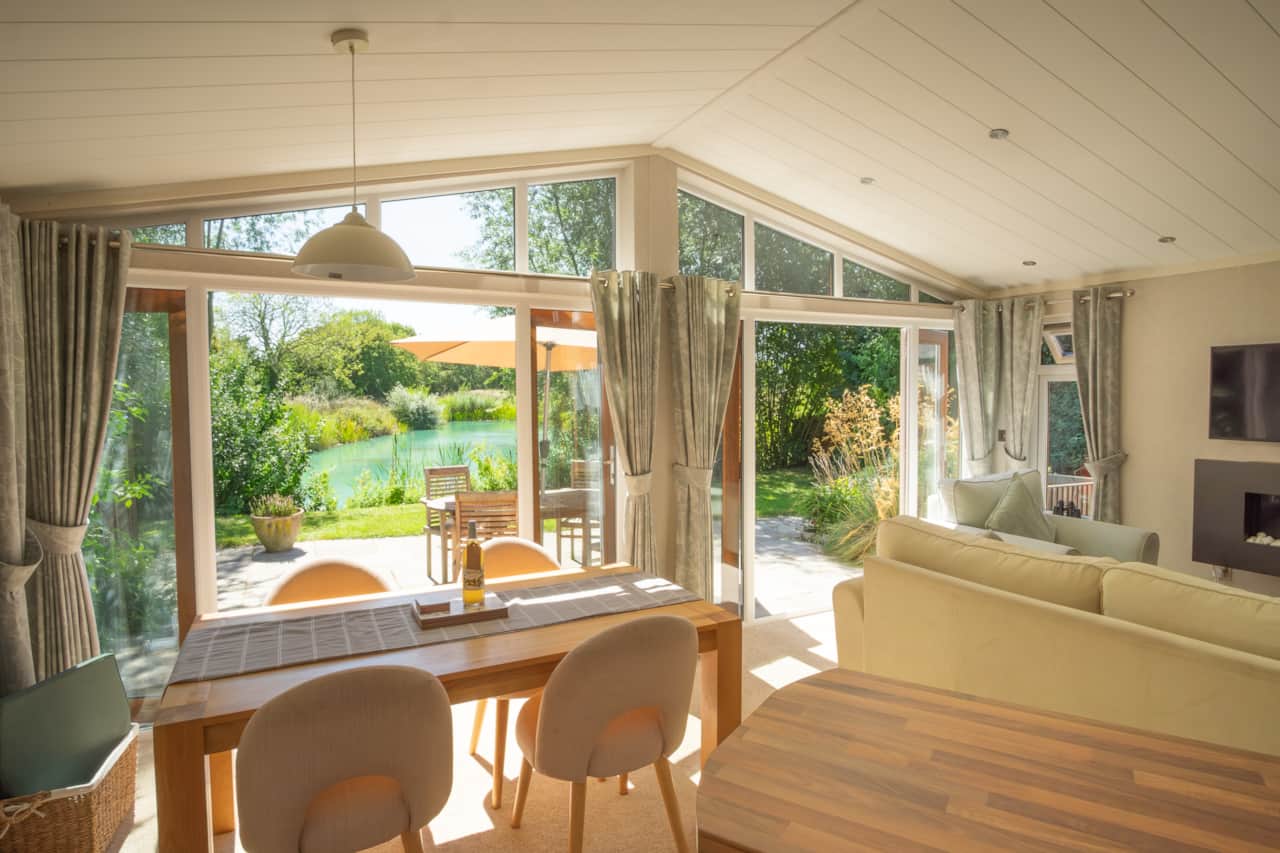 View from the kitchen of the living and dining area in Ash lodge with both double doors open. 
