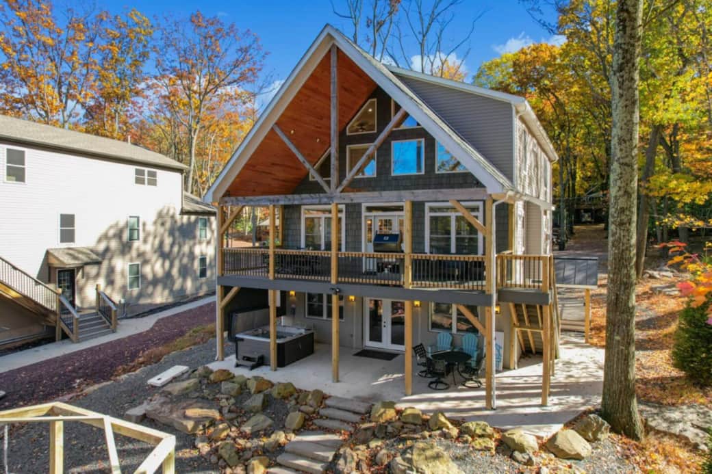 Front of house with hot tub on Patio and deck.