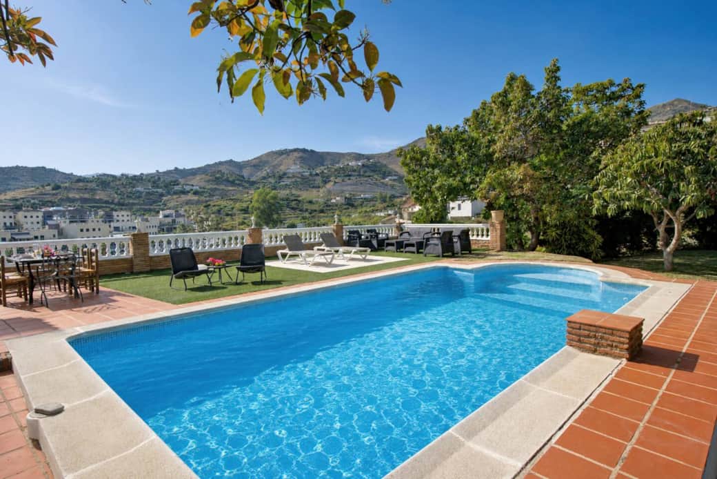 Piscina junto al jardín y zona de comedor exterior